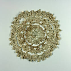 One side of stained cream doily.