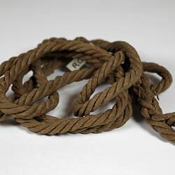 Coil of brown rope made of woven paper.