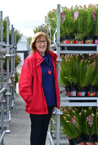 Woman standing in front of rows of plants.