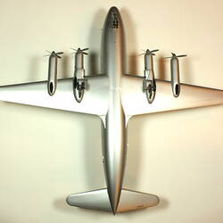 Silver model aeroplane with two propellers on each wing. Underside view.