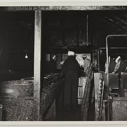 Men inspecting fire damaged factory interior. They wear white hats.