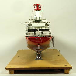 Container ship with red hull rear view.