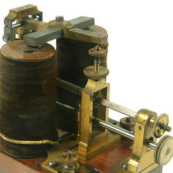 Brass apparatus with battery in centre on wooden base, detail of batteries.