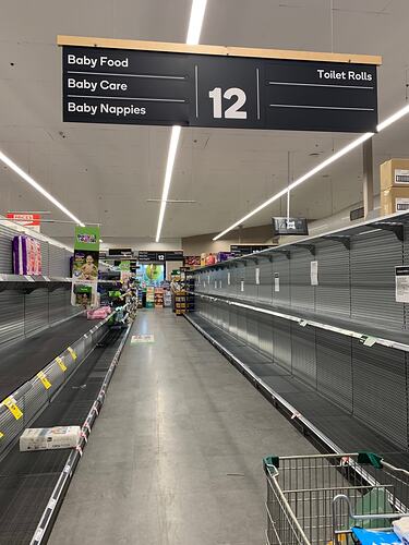 Supermarket aisle with empty shelving.