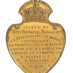 Shield shaped medal with crown atop with raised text.
