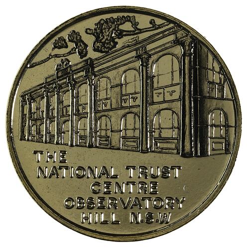 Round medal with double storey building featuring arched windows.