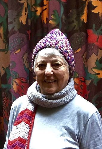 Smiling woman wearing beanie and scarf.