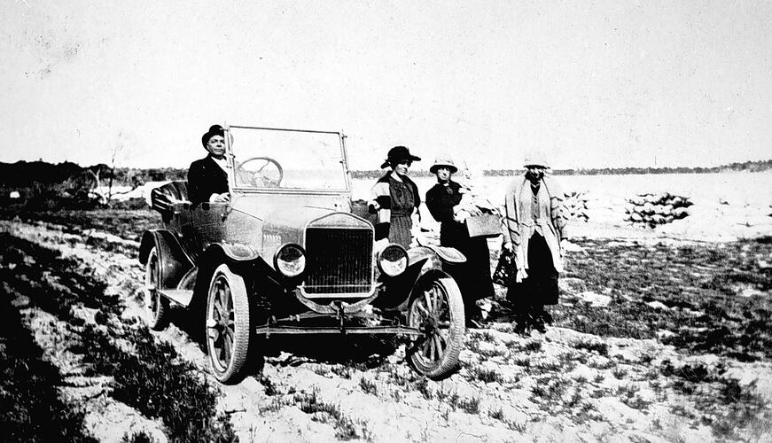 [Picnic party walking beside a touring car, Underbool, 1921. On the rough road the walkers travelled as fast as the car.]