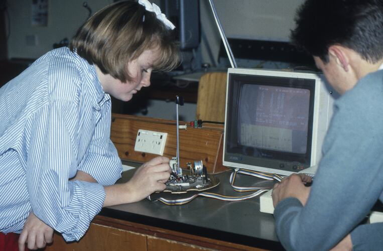 Two students with robotics and a computer.