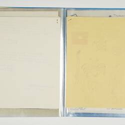 Open blue folder. Blank white page on left. Blank cream stapled pages on right.