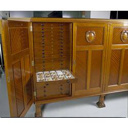 Wooden cabinet with door and drawer open showing eggs.