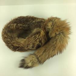Grey furry cap with racoon like tail.
