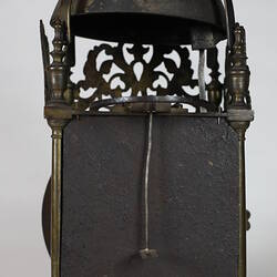 Rectangular metal clock with domed top, rear view.