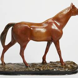 Plaster moulded, hand painted brown horse with a black base. Right profile.