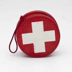 Red yo-yo with white cross. Red string.