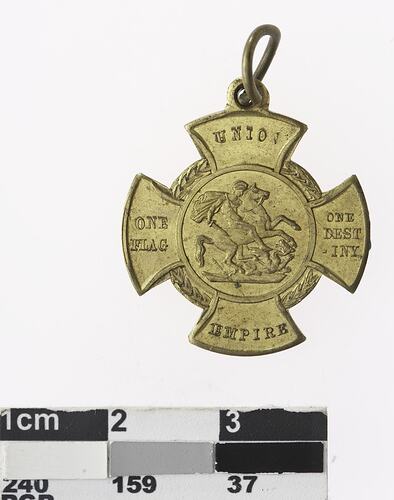 Rounded cross shaped medal with woman on horse and text.