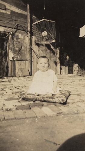 Digital Photograph - Baby on Cushion in Cobbled Backyard, South Melbourne, 1930-1939
