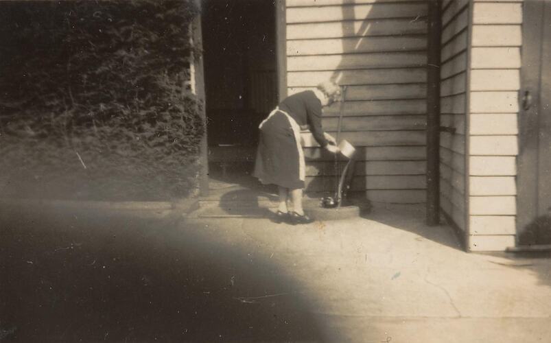 Digital Photograph - Woman Straining Cabbage over Gully Trap, Backyard, Brunswick, circa 1940