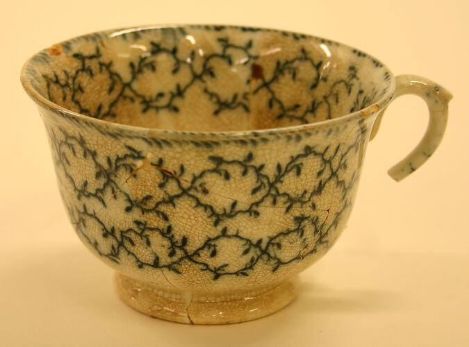 Tea cup with blue/black vine design.