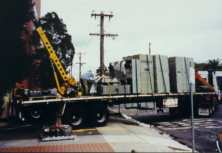 Large sections of machinery being loaded on truck.