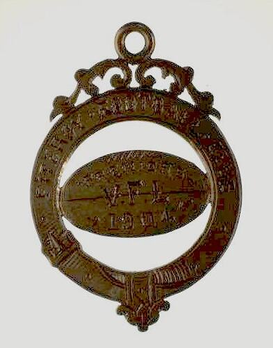 Gold medal with engraved football shape within a circle. Scroll detail above.