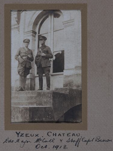 Two servicemen on the front steps of a building.