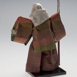 Back view of cloaked paper doll on mount.