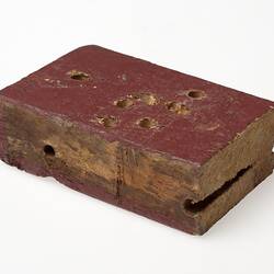 Painted wooden block with holes.