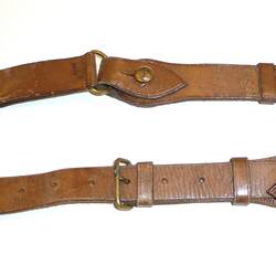 Two brown leather straps, one short, one long, with gold coloured buckles.