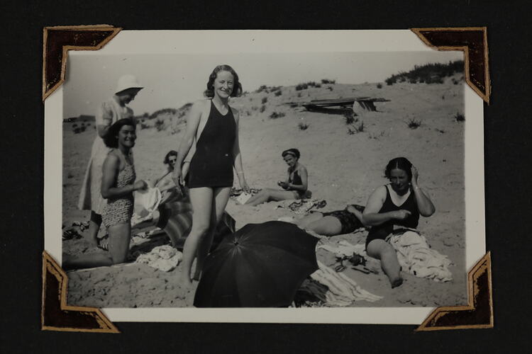 Group of women in bathing suits on beach.