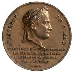 Round medal with male profile facing right. Text below and around.