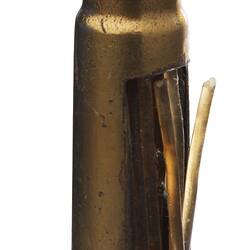 Copper bullet-shaped rifle cartridge with fine tip.