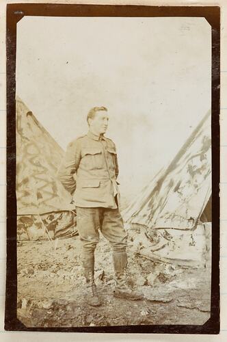 Soldier standing between two tents.
