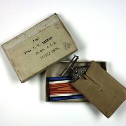 Medal and ribbon inside box packaging.