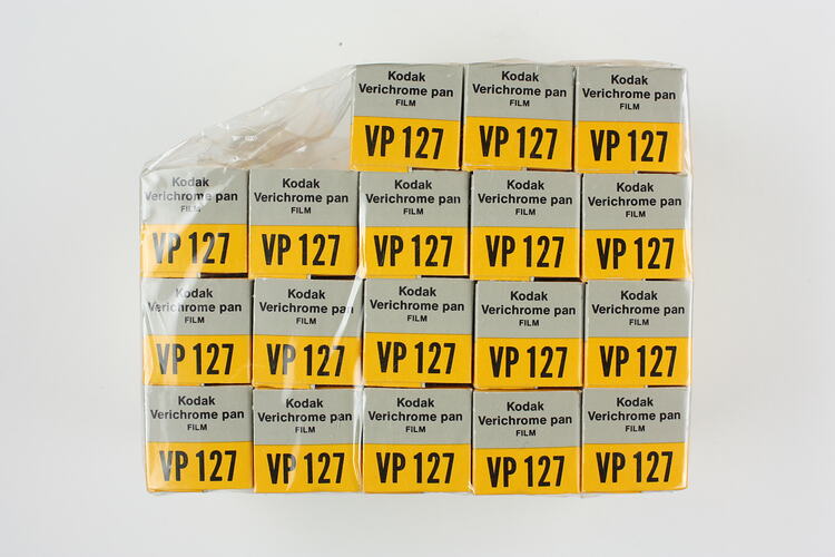 18 grey and yellow cardboard photographic film boxes.