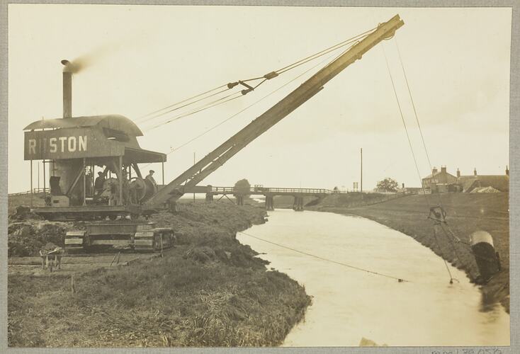 Monochrome photograph of a grab excavator.