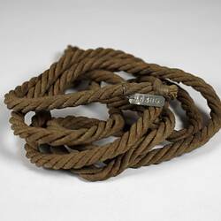 Coil of brown rope made of woven paper.