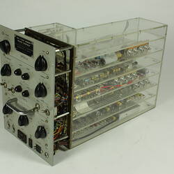 Control panel with knobs and dials. In clear box that shows internal wiring and components.