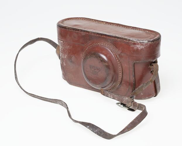 Brown leather camera carry case with shoulder strap.