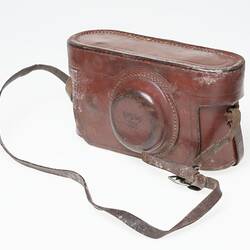 Brown leather camera carry case with shoulder strap.