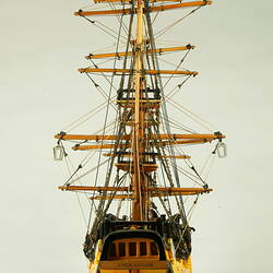 Rear view of model ship with wooden hull and three masts and 'Endeavour' on stern.