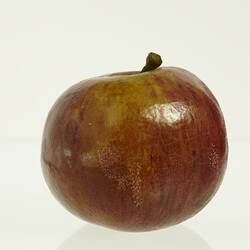 Wax apple model painted dark red. Brown stem.