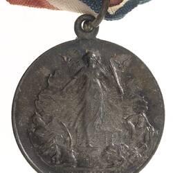 Medal of Peace figure with two flying doves on pedestal. Text below. Loop and ring at top.