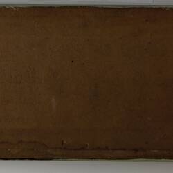 Plain back of a brown exhibition label.