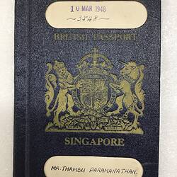 Blue passport cover with gold printed coat of arms. White strip at top and bottom.