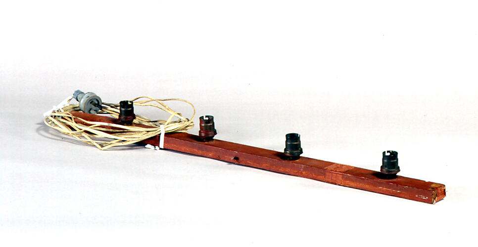 Wooden frame with metal light sockets and cord.