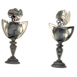 Two earrings each in the shape of a trophy.