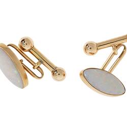 Gold clip cufflinks, each with an oval white opal.