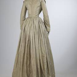 Pale grey striped silk dress with long sleeves and long skirt. Back view.