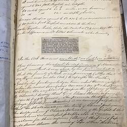 Open bible, white page with black printed and handwritten cursive text.